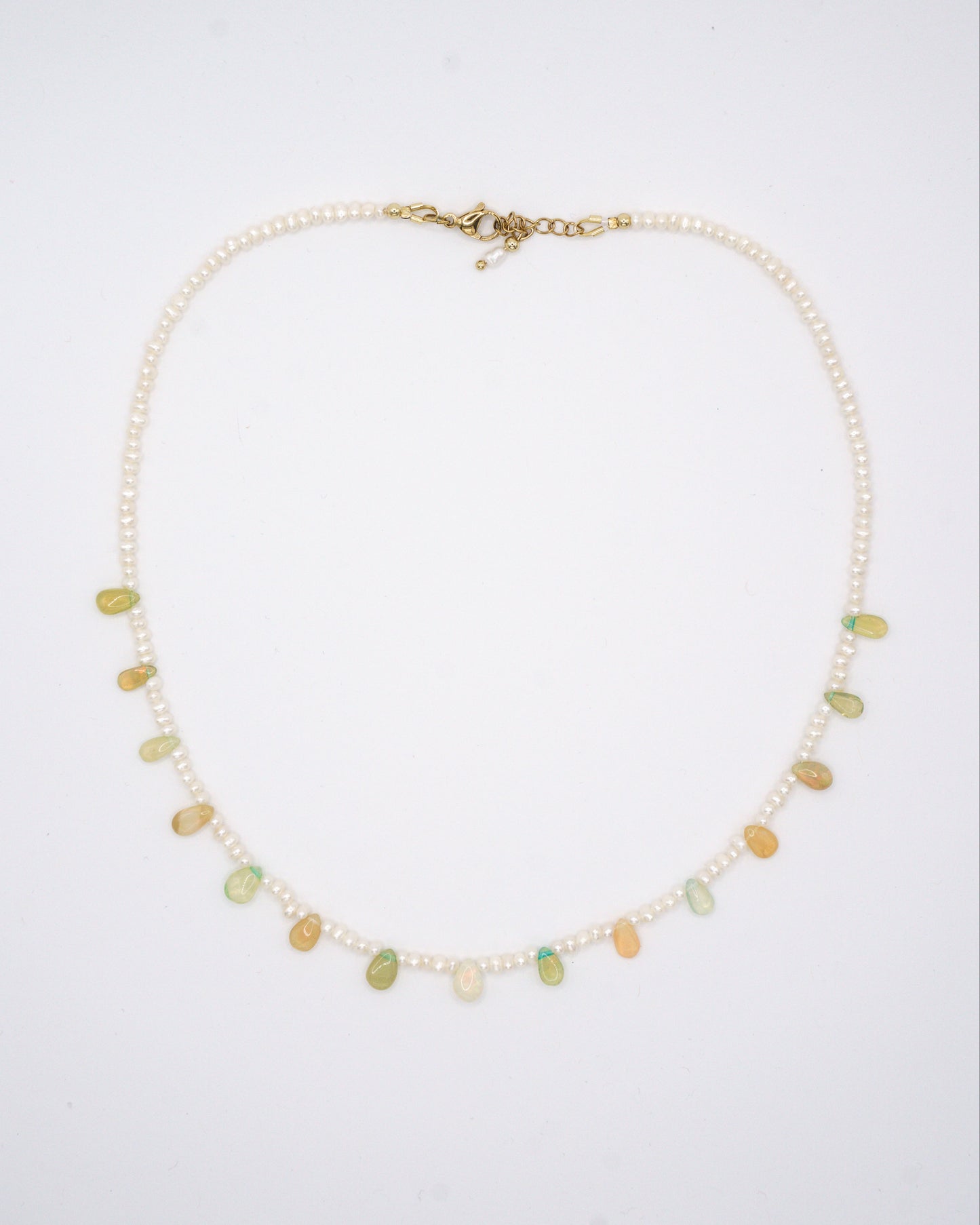 Classic pearl necklace with small freshwater pearls and ethiopian opal droplet gemstones in between.
A timeless white pearl necklace that pairs beautifully with every outfit and sparkles in any light.